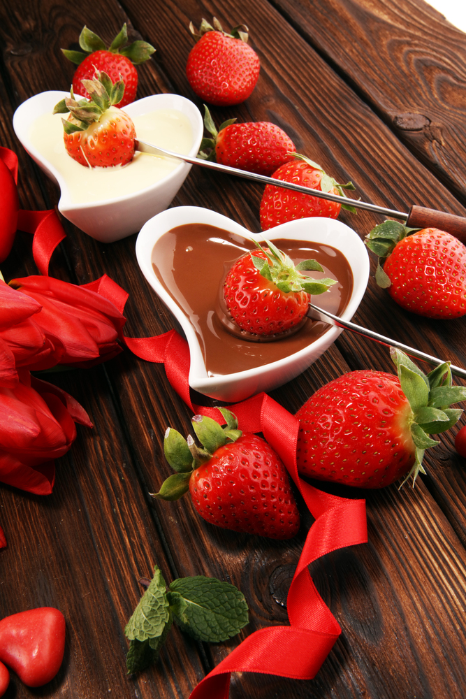 Christmas Chocolate fondue melted with fresh strawberries and dark and white chocolate. Tublips and red sugar hearts