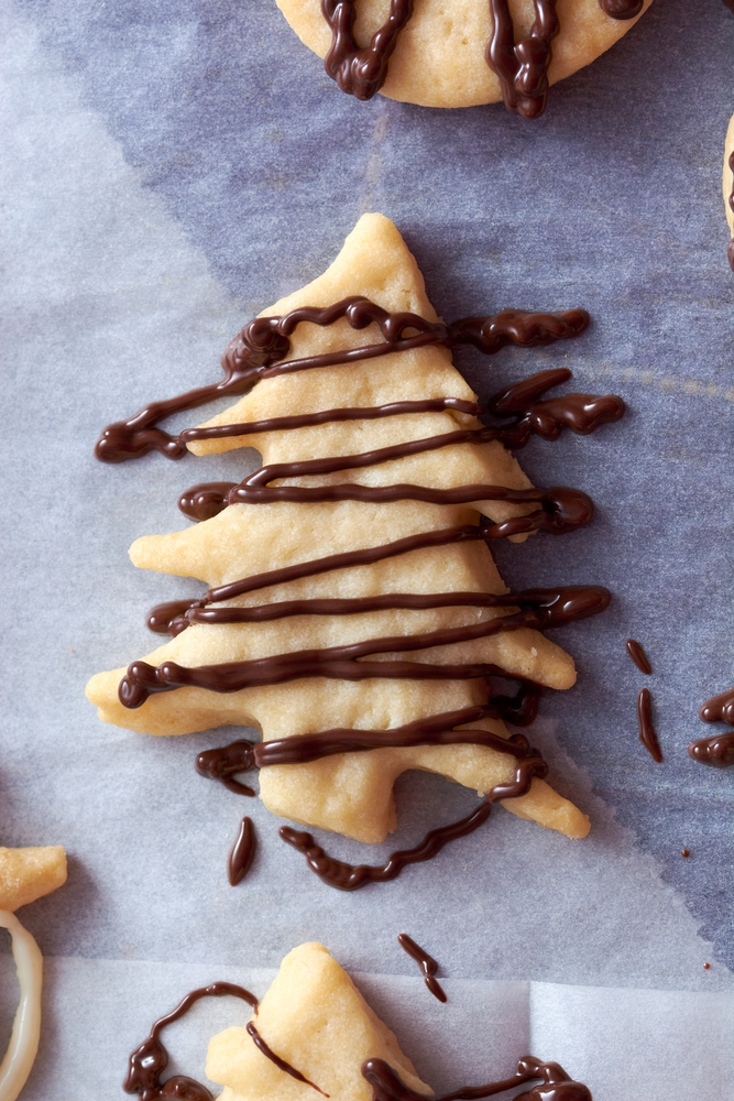 pouring chocolate on just baked christmas dessert cookies